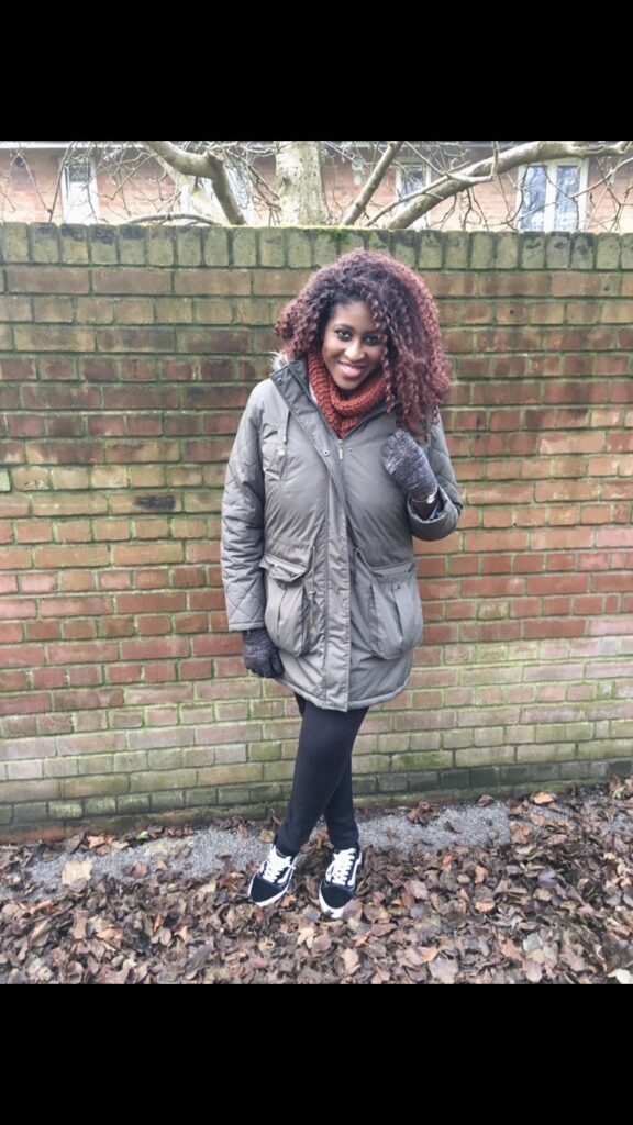 Khaki waterproof jacket, black skinny jeans, black Keds trainers, brick wall backdrop